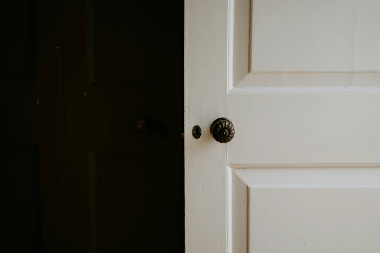a white door with two s and a black handle