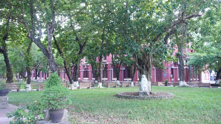 a picture of a graveyard with statues and a building in the background