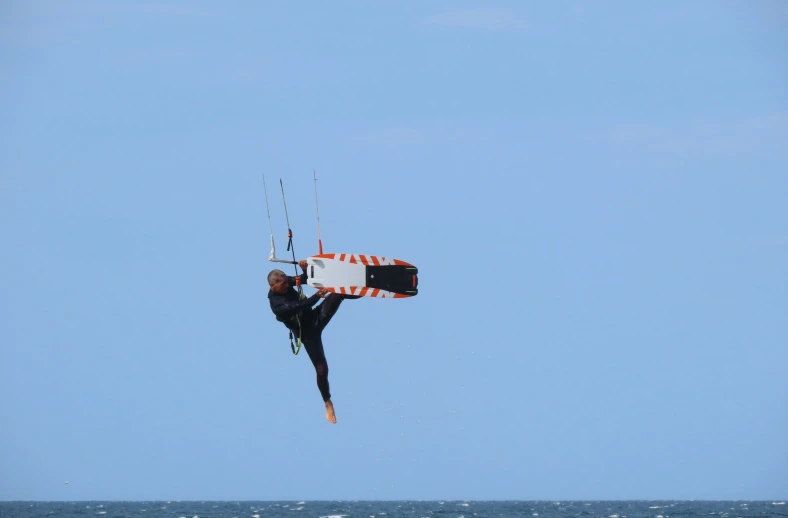 a person is holding on to soing as they are wind surfing