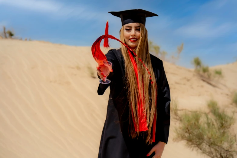 a girl in a graduation gown holding an orange scarf