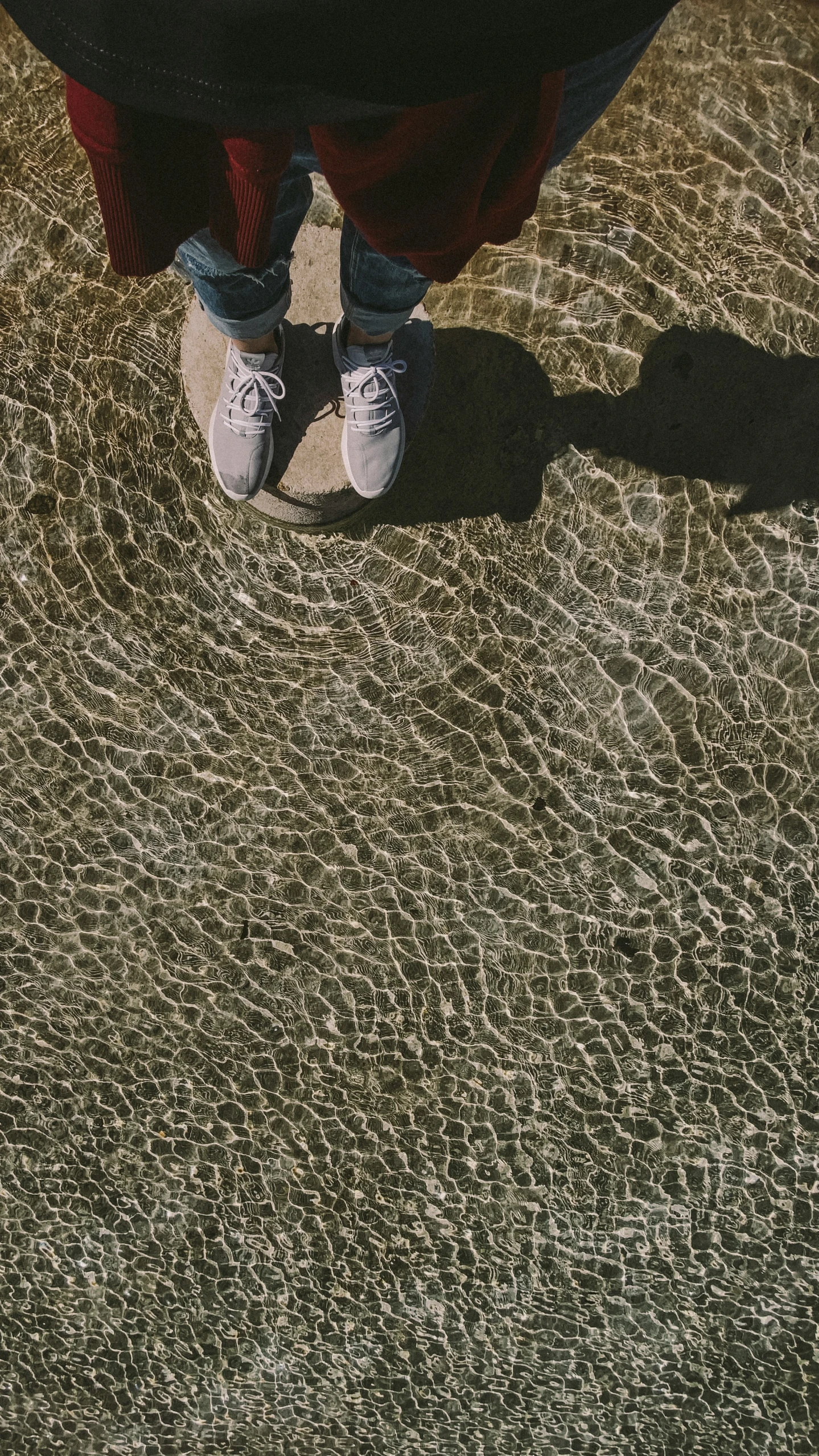 a person is walking on the sidewalk with their shadow