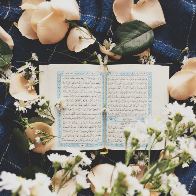 a notebook sitting between flowers and blankets