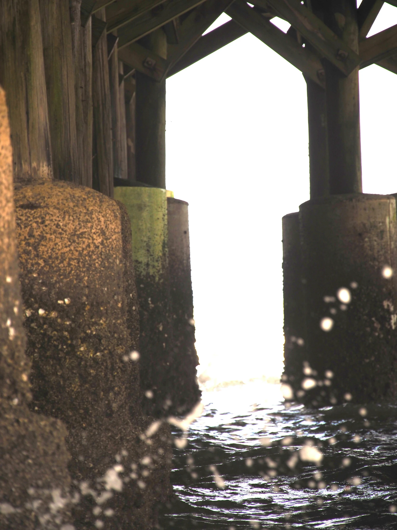 there is a pier with water and light coming down