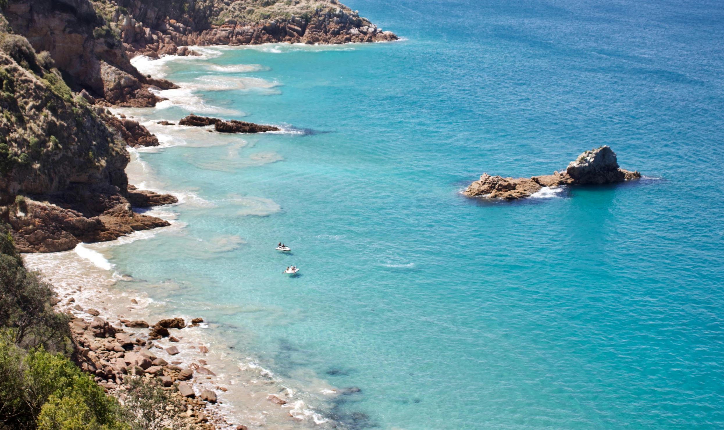 a man paddling a boat in an azure sea