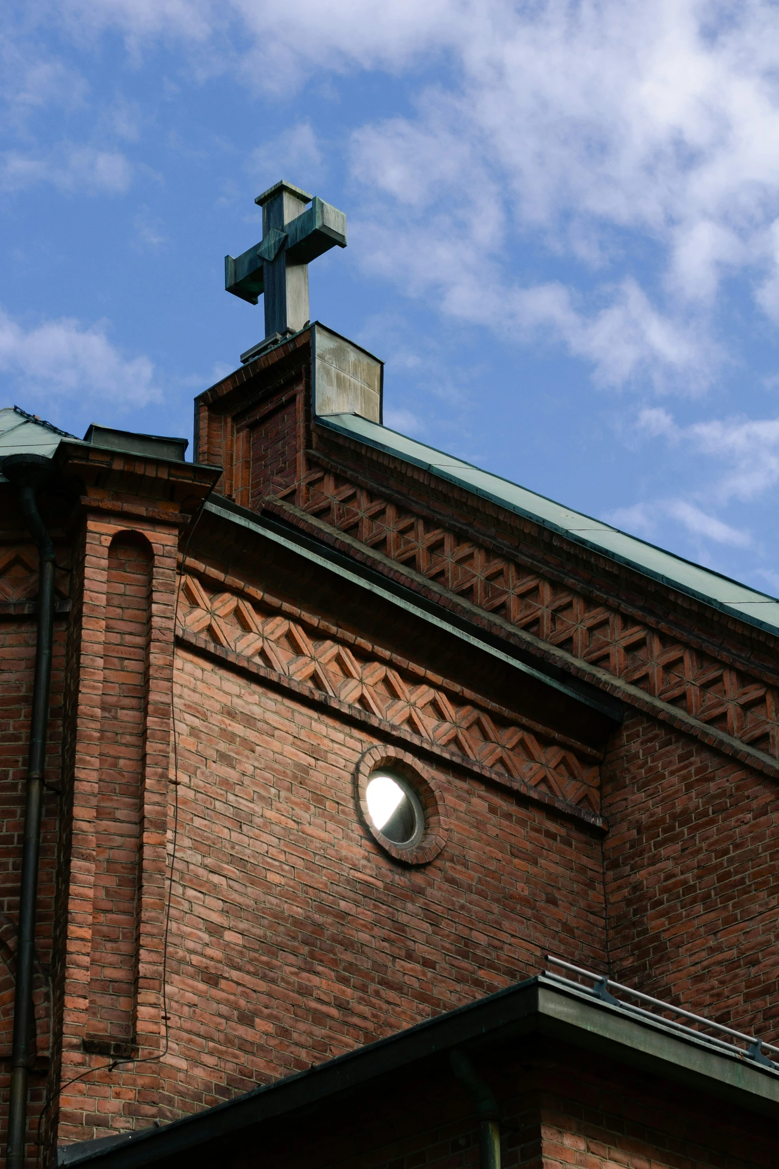 an old church with a cross on top and a light below