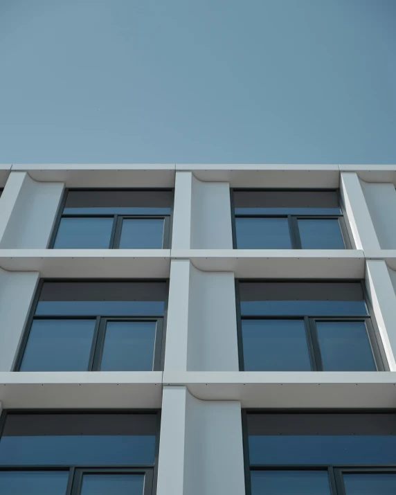 tall gray building with windows under a blue sky