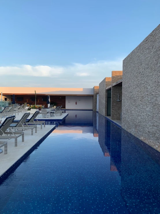 an empty swimming pool with lounge chairs next to it