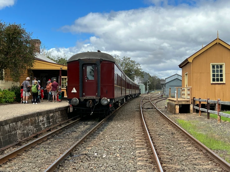 people are standing by the rail cars as it arrives to the station