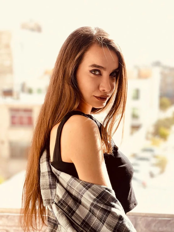 a woman poses for a picture wearing a checkered dress