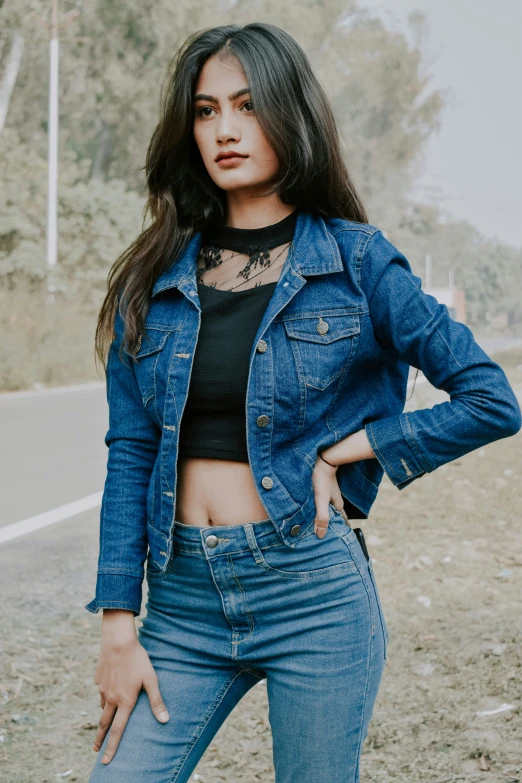 woman wearing ripped denim outfit and jeans leaning up