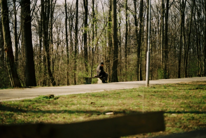 a man rides his skateboard through the woods