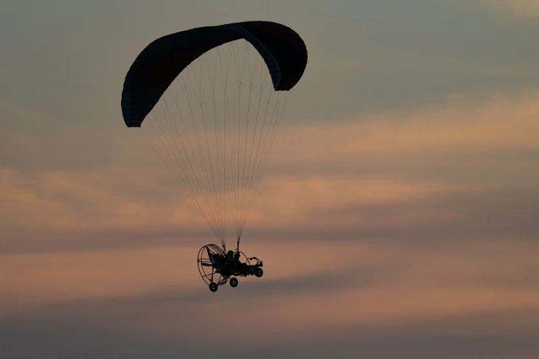 the parasailer is flying over the ocean at sunset