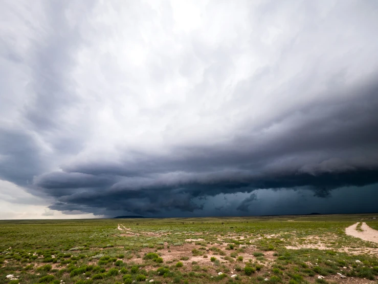 a road is next to a large cloud in the sky