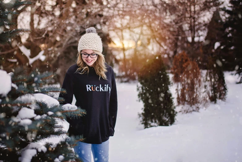 a person in the snow in front of a pine tree