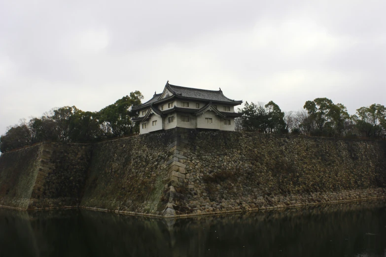 a building on top of a hill next to a river