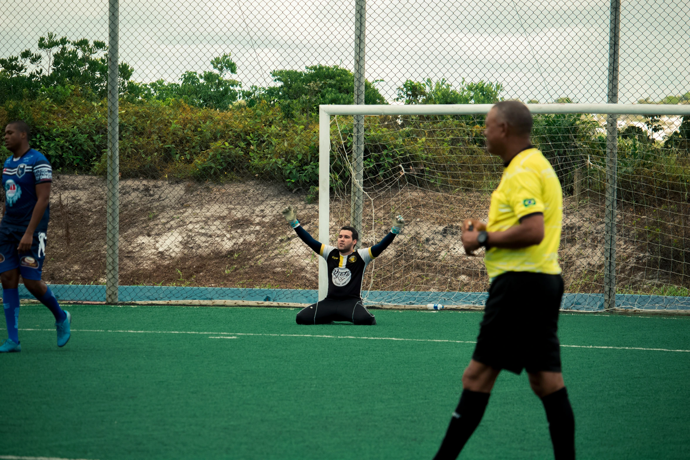 a soccer game between the goal and the referee