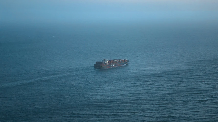 a big boat out in the ocean on a foggy day