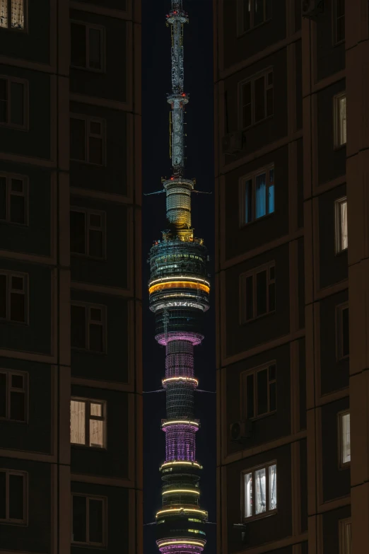 a tall clock tower at night surrounded by tall buildings