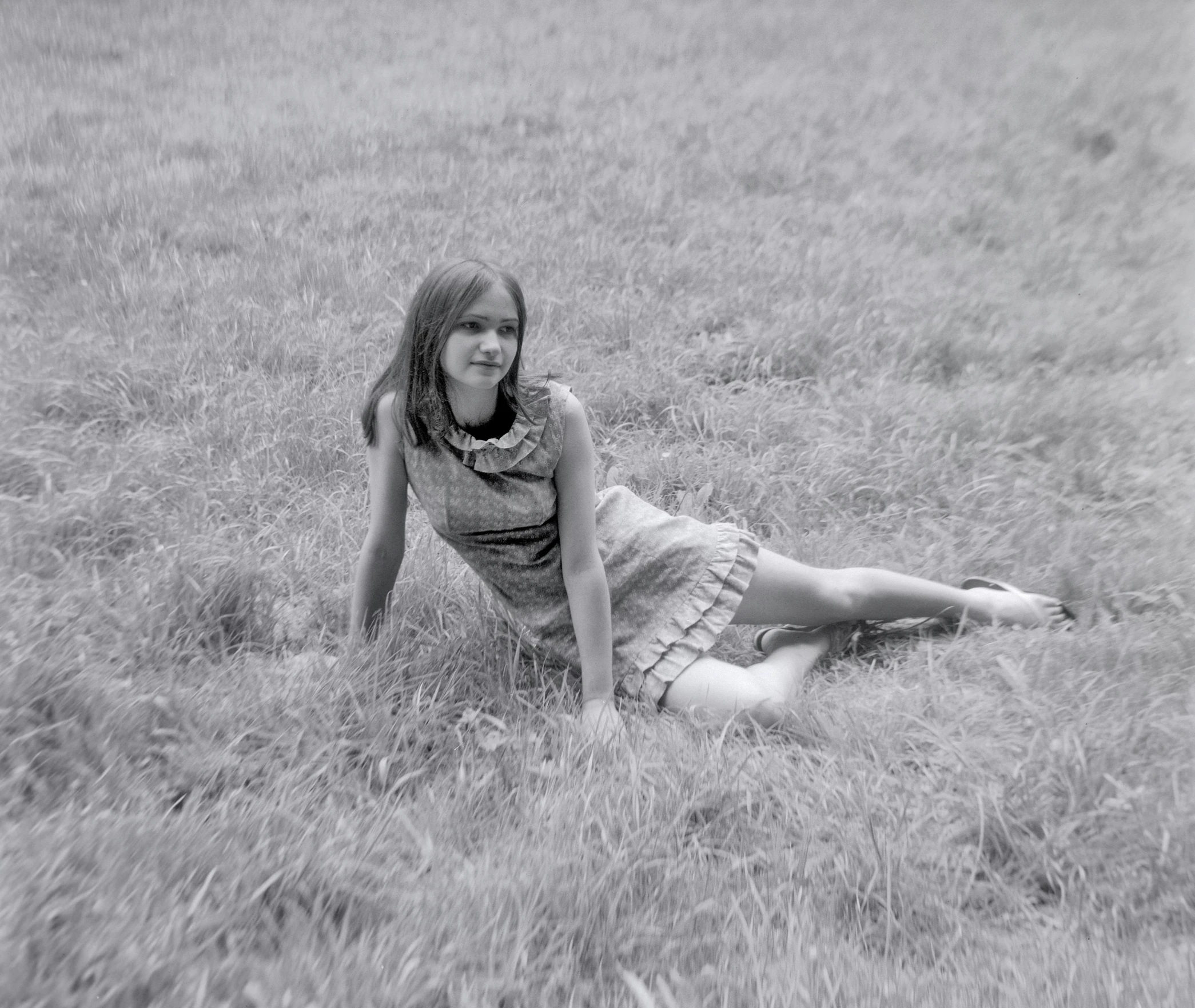 a woman laying in the grass with her leg on the ground