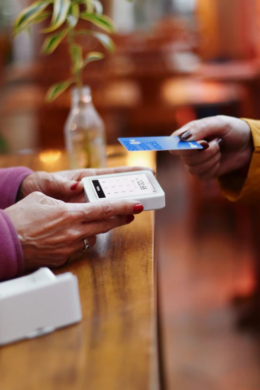 a person holds a plastic card and pays on the touch screen