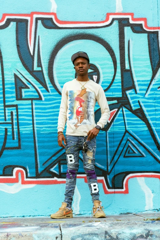 man standing in front of a wall with graffiti