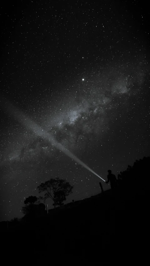 a person watching the stars at night in a field