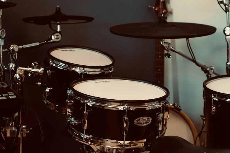 three drums sit near the headphones in a recording studio