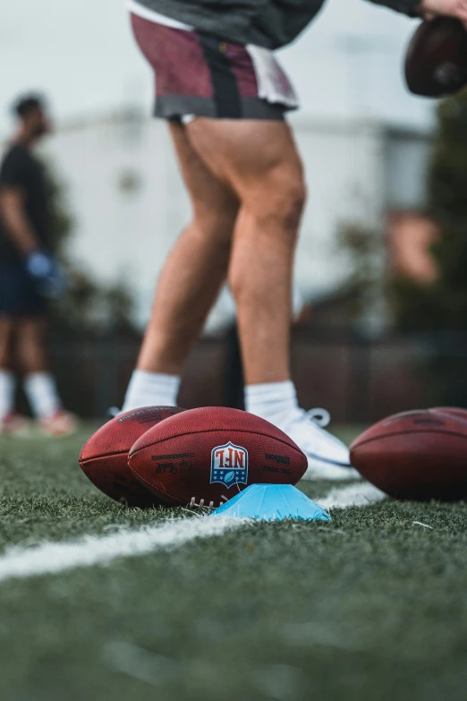 a football on the ground with a football laying next to it