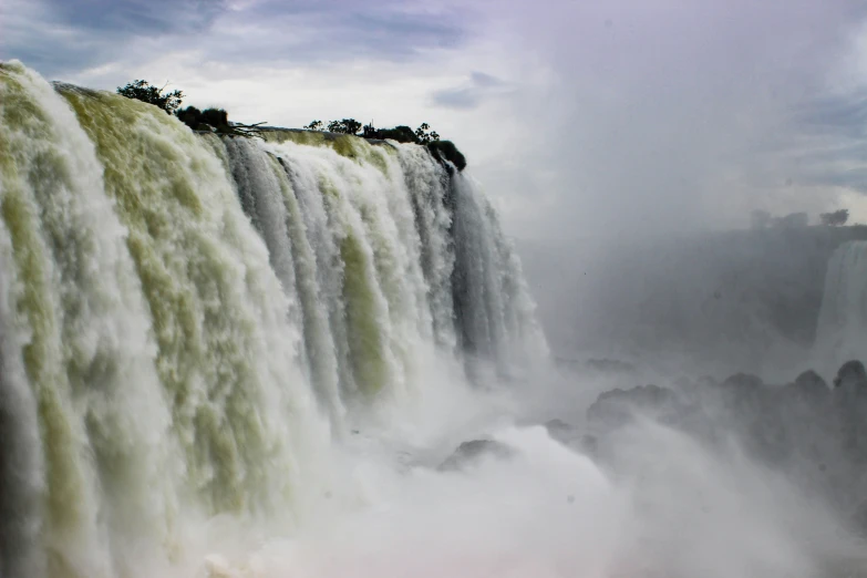 the water is spraying down the falls and is grey