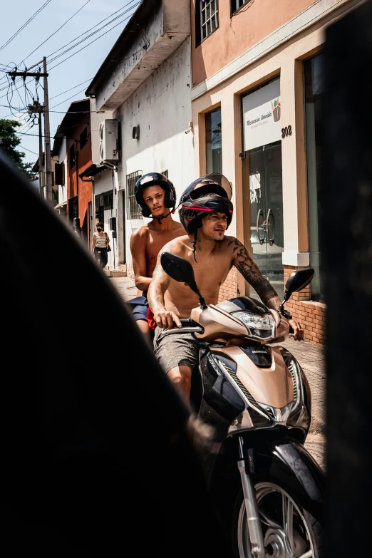 two people on a motor bike in the street