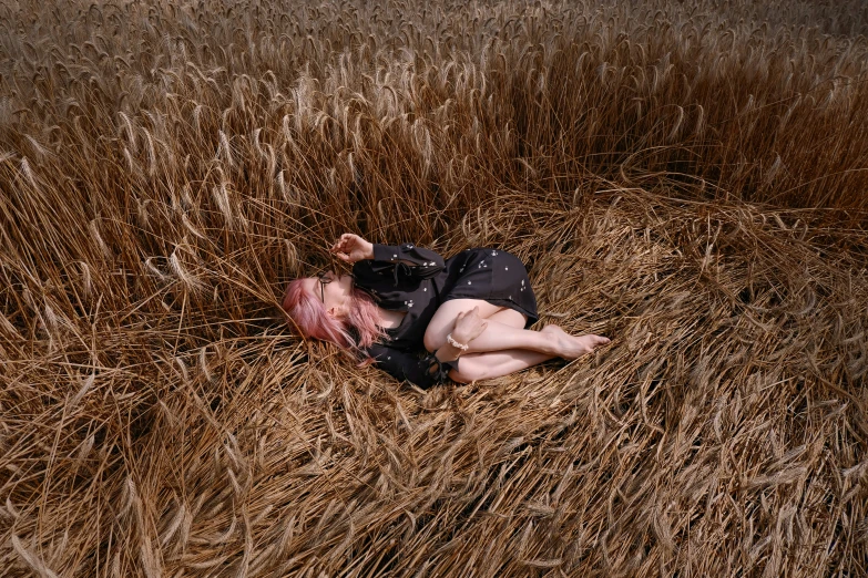 a person laying on the ground surrounded by hay