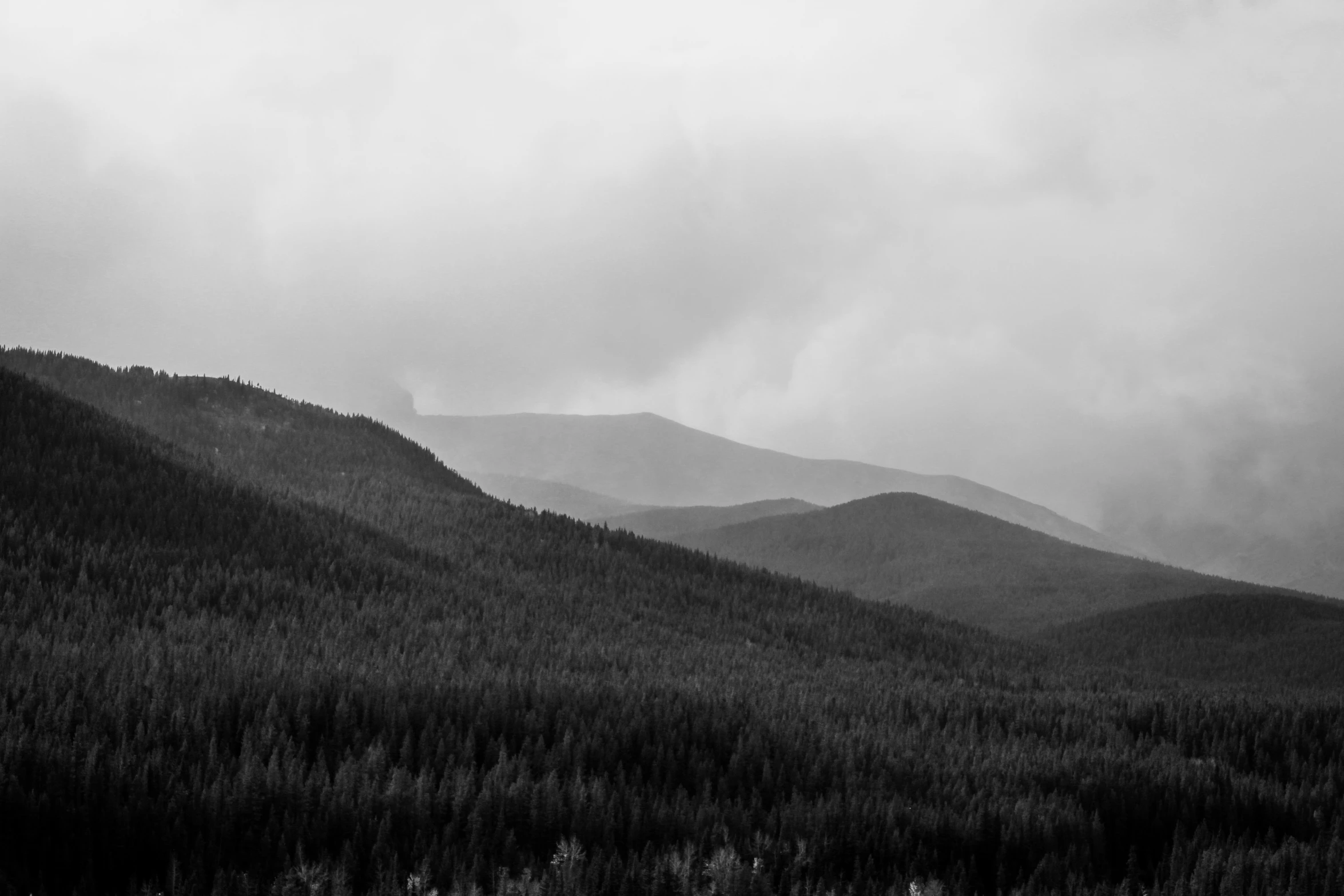 the clouds are gathering at the top of the mountains