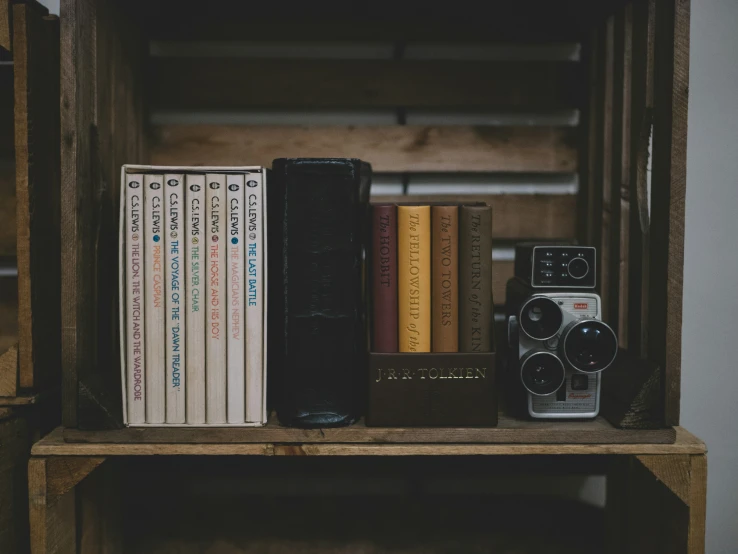 a bookshelf with a camera and several different books