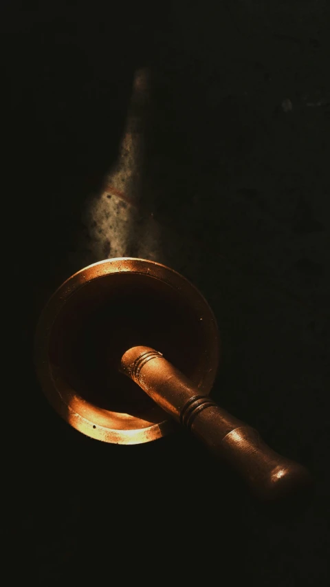 a wooden spoon with a black background and dark surface