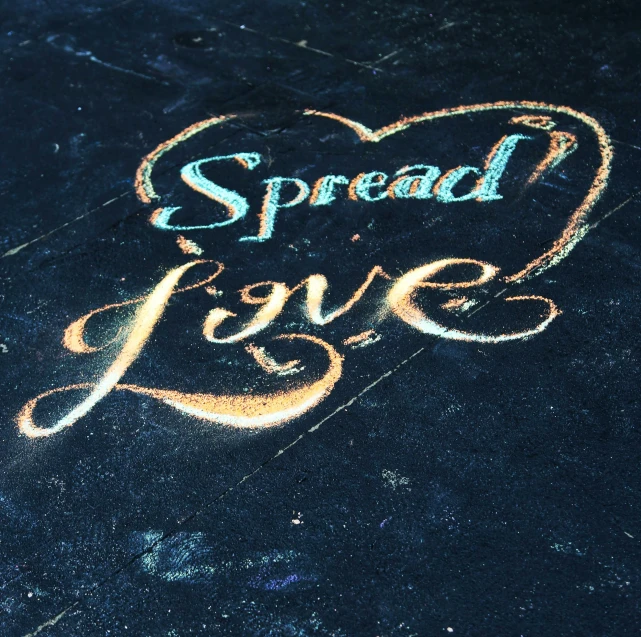 chalk writing reading spread love is drawn on a sidewalk