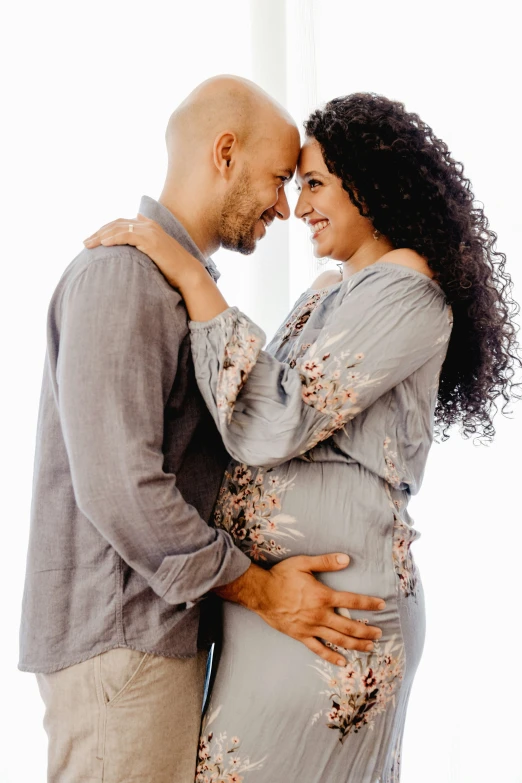 a pregnant couple poses for a portrait together