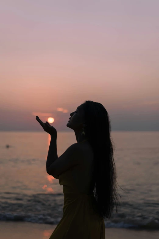 a beautiful woman standing on top of a sandy beach