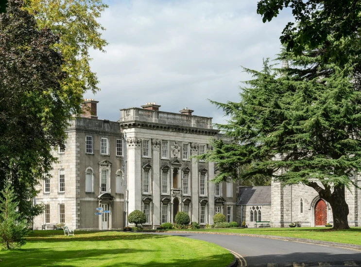 an elegant old building in front of some trees