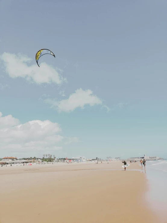 a beach scene with a kite flying in the air