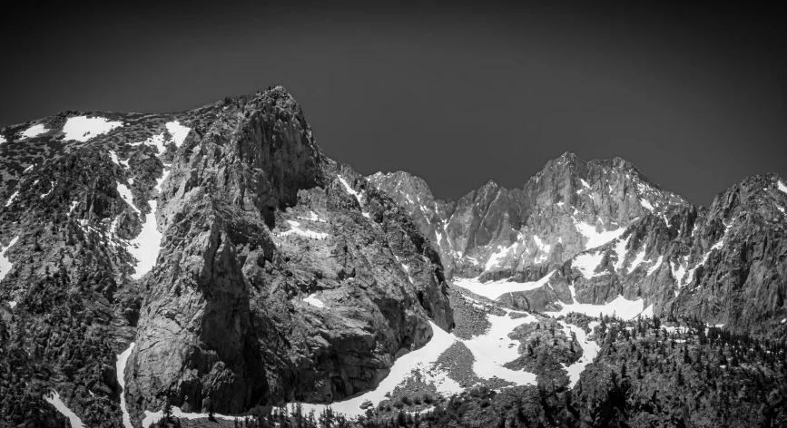 the mountains are snow covered with trees