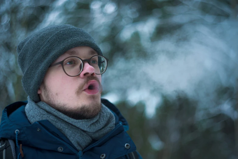 a close - up of a person with glasses and a beanie