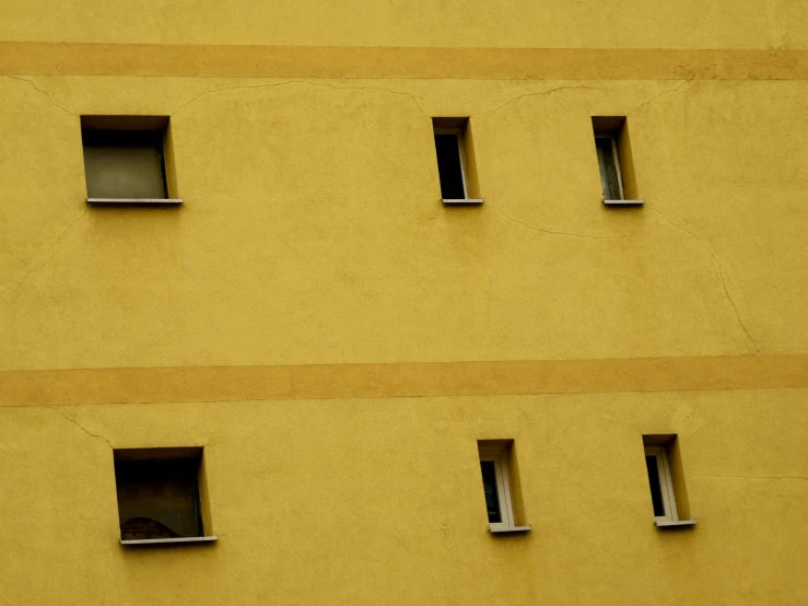 some small windows are seen on the side of a building