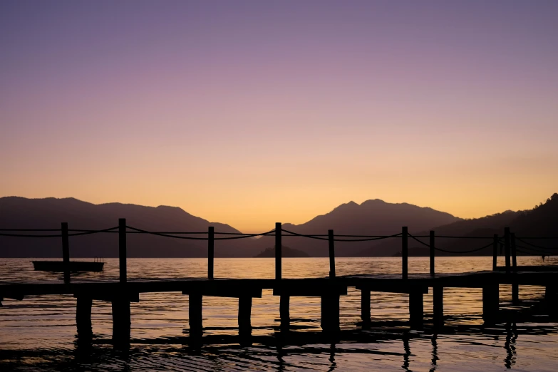 a dock is shown in front of a mountain range