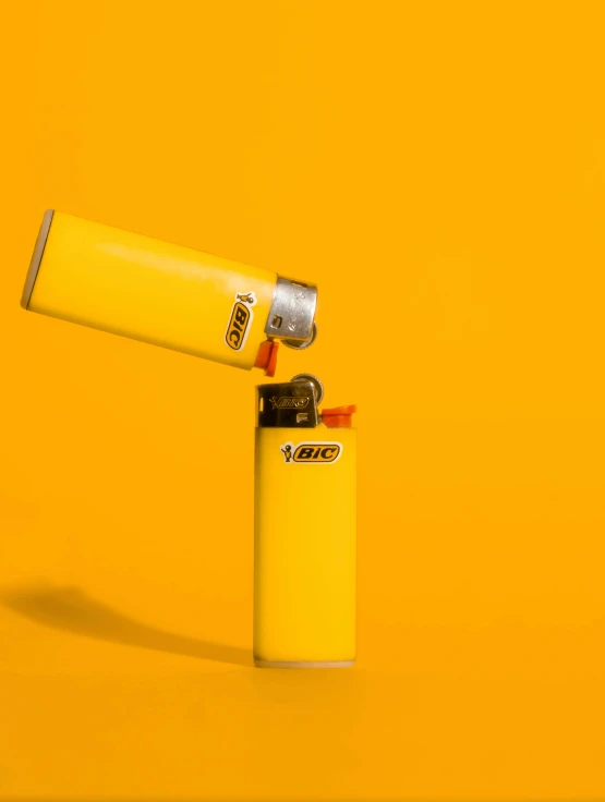 the yellow lighter is sitting against the wall