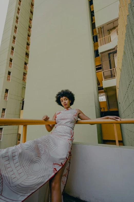 a woman poses near a city apartment building