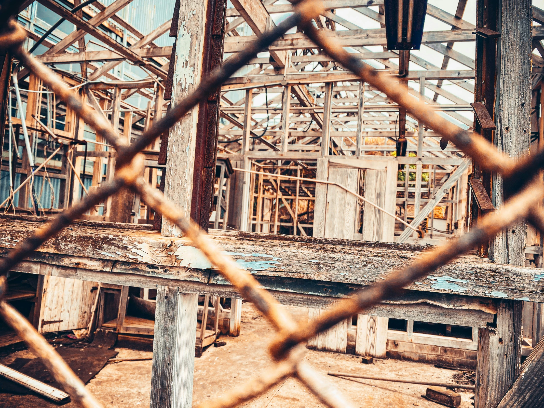 an old building being constructed by the sun through the fencing