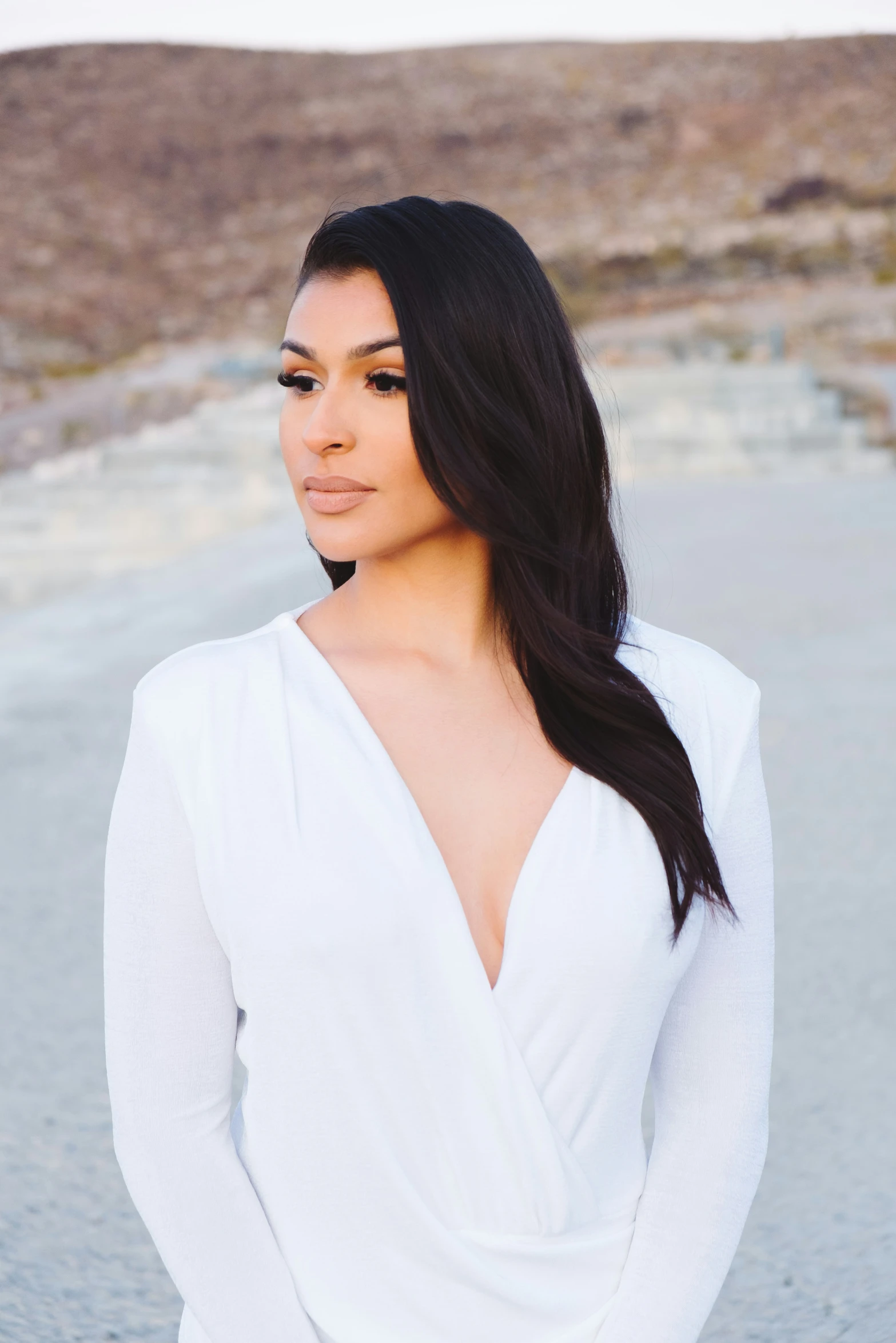 a young woman in white standing on the beach