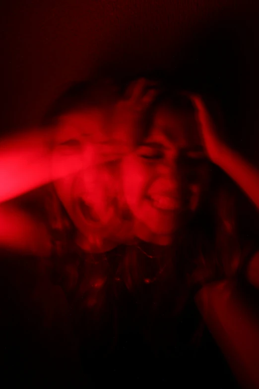 a woman in red is in a dark room and smiling