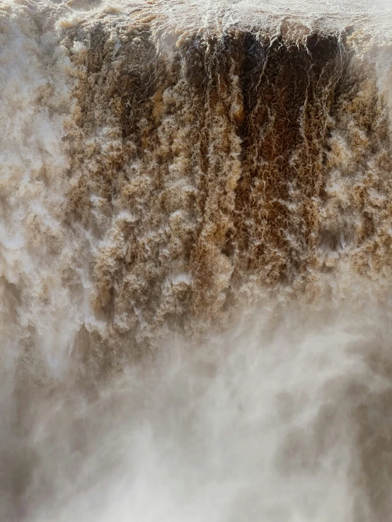 the water is pouring out of the top of a waterfall