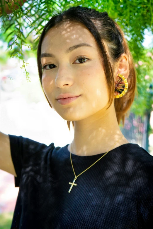 a close up of a young person with earrings on